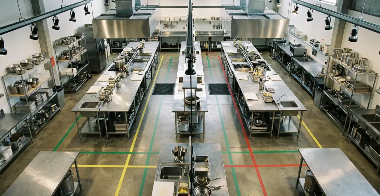 Vue aérienne d'une cuisine professionnelle avec marquage au sol coloré et zones de travail délimitées