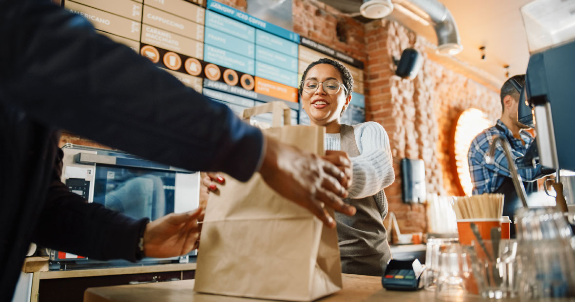 Client récupérant commande en bol carton au comptoir restaurant vente à emporter